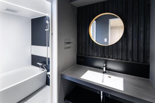 a bathroom with a sink and a mirror at SITSURAE OSAKA Hommachi/Shinsaibashi-Kita in Osaka