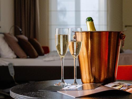 - deux verres de champagne dans un seau à glace sur une table dans l'établissement Hotel L'O de Vie, à Saint-Trond
