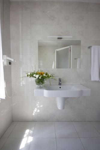a white bathroom with a sink and a mirror at Hotel butikowy Pałac Jabłonna in Jabłonna