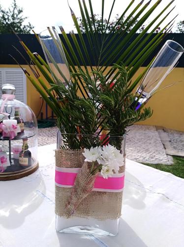 a vase with flowers in it on a table at Quinta Salinas - Puro Prazer in Aveiro
