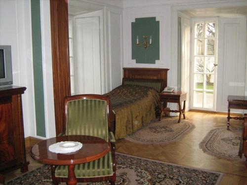 a bedroom with a bed and a table and chair at Hotel butikowy Pałac Jabłonna in Jabłonna