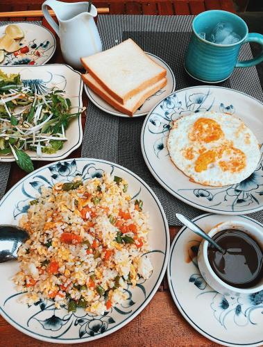 ein Tisch mit Tellern mit Reis, Eiern und Brot in der Unterkunft Villa De Campagne Hoi An- Boutique homestay with pool and family soul in Hoi An