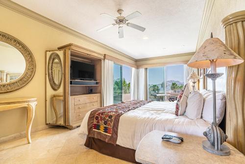 a bedroom with a bed and a large window at Villa La Estancia - Medano Beach Villas in Cabo San Lucas