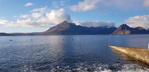a large body of water with mountains in the background at Tigh Lachie, Mary's Thatched Cottages, Elgol, Isle of Skye in Elgol
