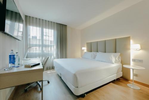 sypialnia z dużym białym łóżkiem i biurkiem w obiekcie Hesperia Murcia Centro w Murcji