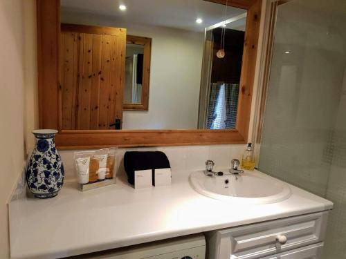 a bathroom with a sink and a mirror at Tigh Lachie, Mary's Thatched Cottages, Elgol, Isle of Skye in Elgol