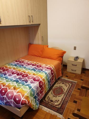 una cama con un edredón colorido en una habitación en Tranquillità e cordialità a 30 minuti da MIlano, en Busto Arsizio