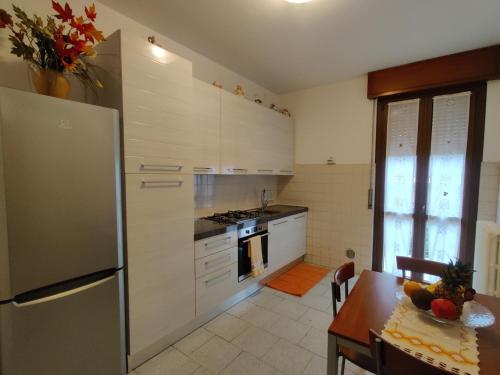 a kitchen with a stainless steel refrigerator and a table at Tranquillità e cordialità a 30 minuti da MIlano in Busto Arsizio
