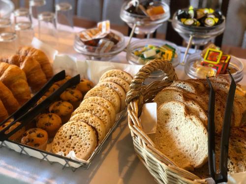 Una mesa cubierta con cestas de pan y pasteles en Oaklands by Greene King Inns, en Chester