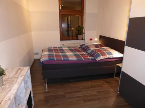 een slaapkamer met een bed met een geruite deken bij weiss-ferienwohnung in Quedlinburg