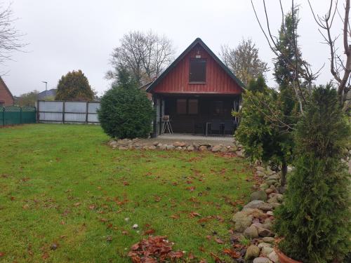 a small house with a red roof in a yard at Sunnesching 2 in Sankt Michaelisdonn