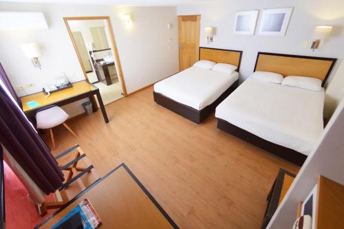 a hotel room with two beds and a desk at Centro 19 Hotel in Querétaro