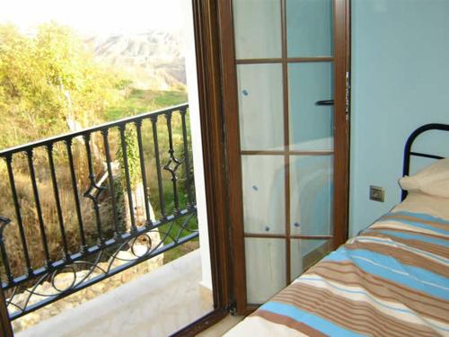 a room with a balcony with a bed and a window at Casa Mamica Rosario in Yegen