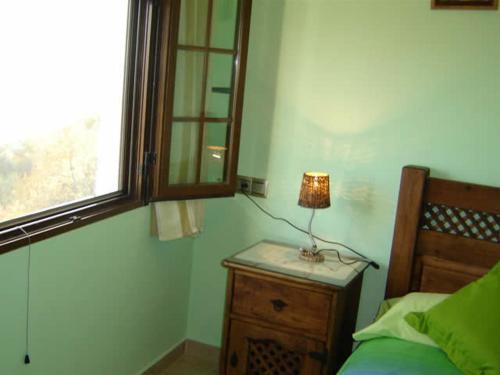 a bedroom with a bed and a lamp on a night stand at Casa Mamica Rosario in Yegen
