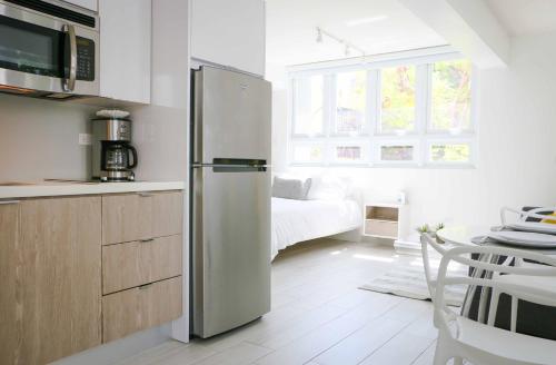 einen Kühlschrank aus Edelstahl in einer Küche mit einem Bett in der Unterkunft Avila Guesthouse in San Juan