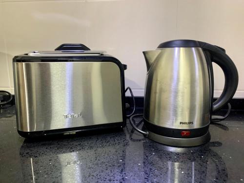 a toaster and a tea kettle on a counter at Relaxed Family Staycation, Pool View w WIFI n Netflix in Bangi