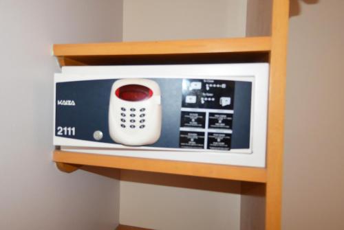 a microwave with a remote control sitting on a shelf at Centro 19 Hotel in Querétaro