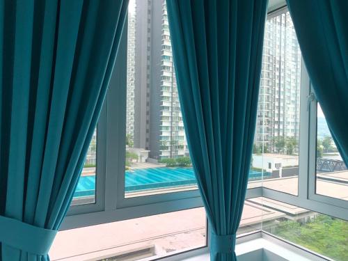 a view from the window of a building with blue curtains at Relaxed Family Staycation, Pool View w WIFI n Netflix in Bangi