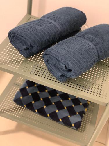 a shelf with two blue towels and a tie at Relaxed Family Staycation, Pool View w WIFI n Netflix in Bangi
