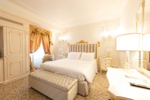 a bedroom with a large white bed and a chair at Ca' Bonfadini Historic Experience in Venice
