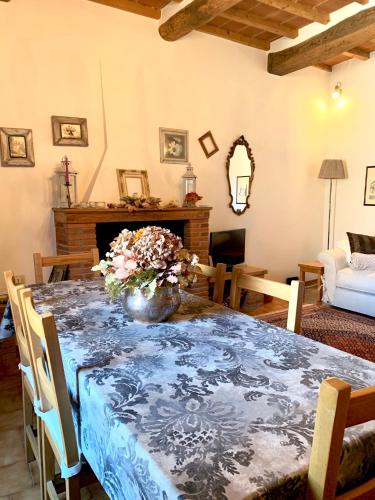 a dining room with a table with a vase of flowers on it at Dolcevita Chianti Apartments in Radda in Chianti