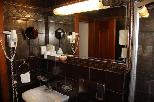 a bathroom with a sink and a mirror at Hotel Tyrolis in Zirl