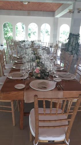 a long wooden table with chairs and plates and wine glasses at The Lorian Club in Cocoyoc