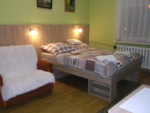 a bedroom with a bed and a chair at Góściniec Iwona in Głuchołazy