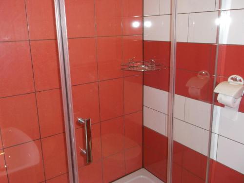 - czerwono-białą łazienkę z prysznicem w obiekcie Góściniec Iwona w mieście Głuchołazy