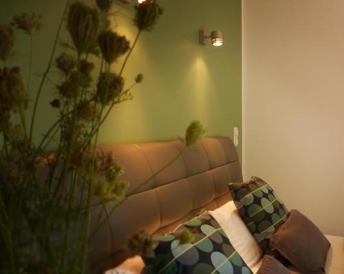 a living room with a couch and a vase with flowers at Trafohaus am Kaiserbahnhof in Brühl