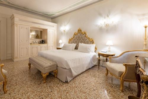 a bedroom with a large bed and two chairs at Ca' Bonfadini Historic Experience in Venice