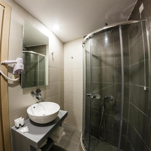 a bathroom with a sink and a shower at Porto Planos Beach Hotel in Tsilivi