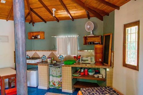 una pequeña cocina con encimera en una habitación en Chalé Ipê - Jatobá en Alto Paraíso de Goiás