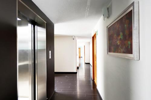 a hallway with a painting on the wall and a hallway with at Centro 19 Hotel in Querétaro