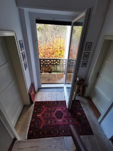 an empty hallway with an open door and a rug at Dolomiti house in Cibiana