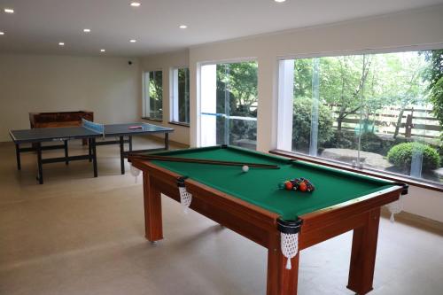 a billiard room with a pool table and a window at Hotel Matsubara in Campos do Jordão