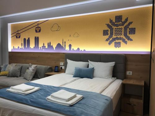 a bedroom with a large bed with towels on it at OLYMPIC 84 Apartments in Sarajevo