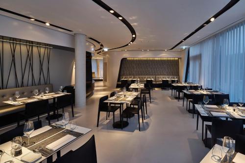 a restaurant with tables and chairs in a room at Hotel Campus At Home in Planegg