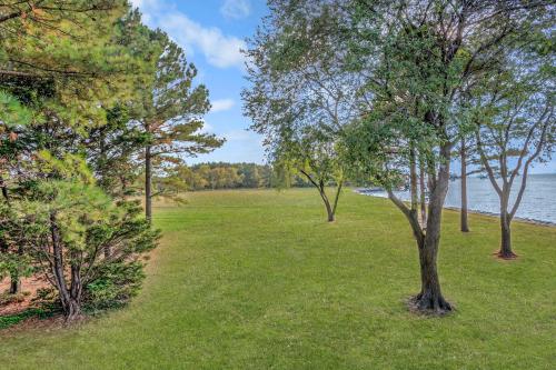 a field of grass with trees and a body of water at Wades Point Inn on the Bay in Saint Michaels