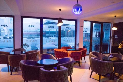a restaurant with tables and chairs and windows at My Way in Bumbeşti-Jiu