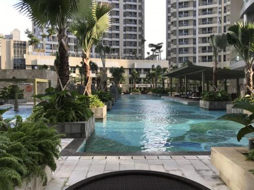 ein großer Pool mit Palmen und Gebäuden in der Unterkunft 1 BR Apartment Near Shopping Malls in Jakarta