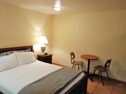 a bedroom with a bed and a table and chairs at Apartotel Don Francisco in San José