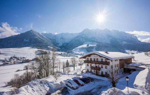 a building on top of a snow covered mountain at Ferienhof Auerhof in Walchsee