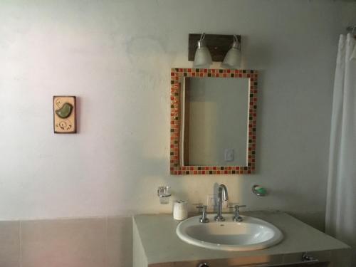 y baño con lavabo y espejo. en Les Passants - Comoda casa de dos plantas en Mar Azul en Balneario Mar Azul