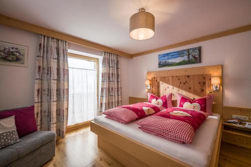 a bedroom with a bed with red and white pillows at Ferienhof Auerhof in Walchsee