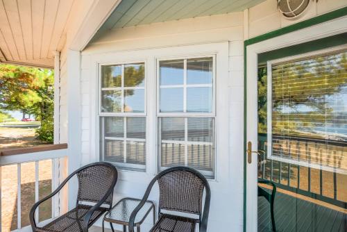 a front porch with two chairs and a door at Wades Point Inn on the Bay in Saint Michaels