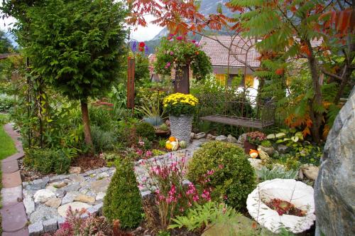 a garden with a bench and flowers and plants at Thalerhof in Roppen