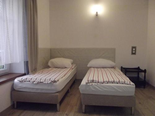 two twin beds in a room with a window at Apartament Nad Kamienną 2 in Jelenia Góra
