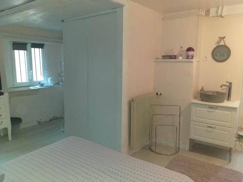 Schlafzimmer mit einem Bett, einer Theke und einem Waschbecken in der Unterkunft Chambres d'Hôtes Selon Morphee in Selongey