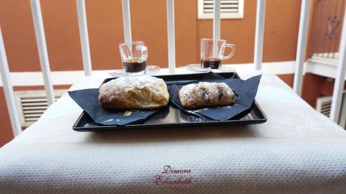 two donuts on a plate on a table with drinks at Dimora Elizabeth II in Modugno